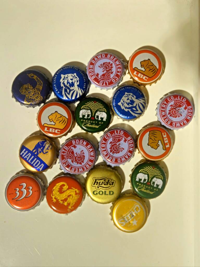 Selection of beer bottle caps from Asia including Hanuman Lager, Chang, Bia Saigon and 333 Lager