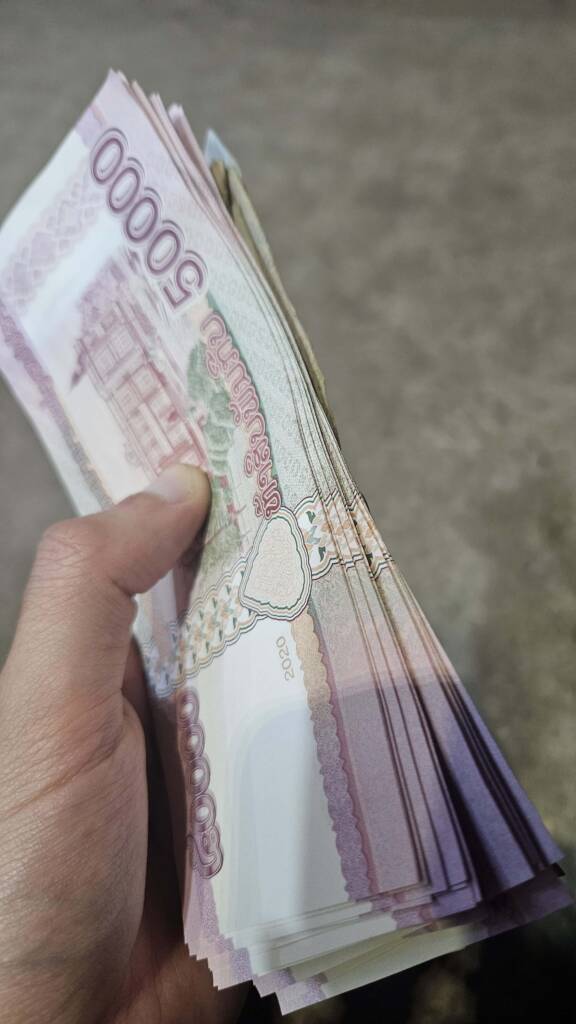 backpacker holding laotian money
