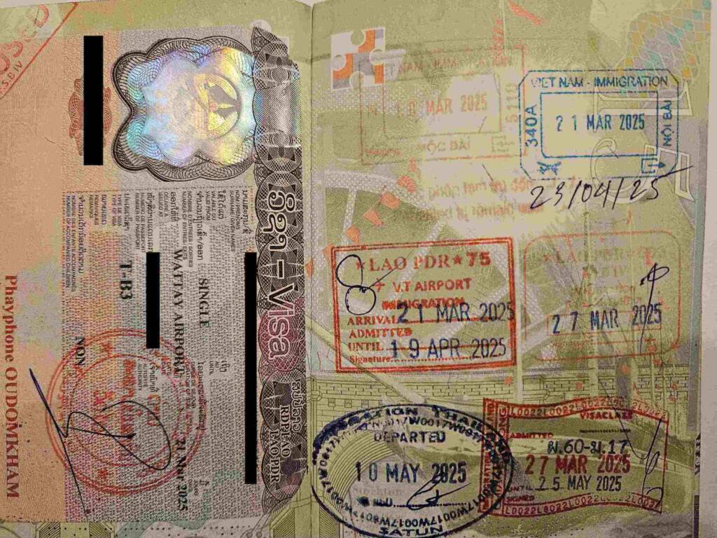 Close-up of a passport filled with visa entry and exit stamps from countries in Southeast Asia, illustrating the process of border crossing for a 6 month backpacking trip.