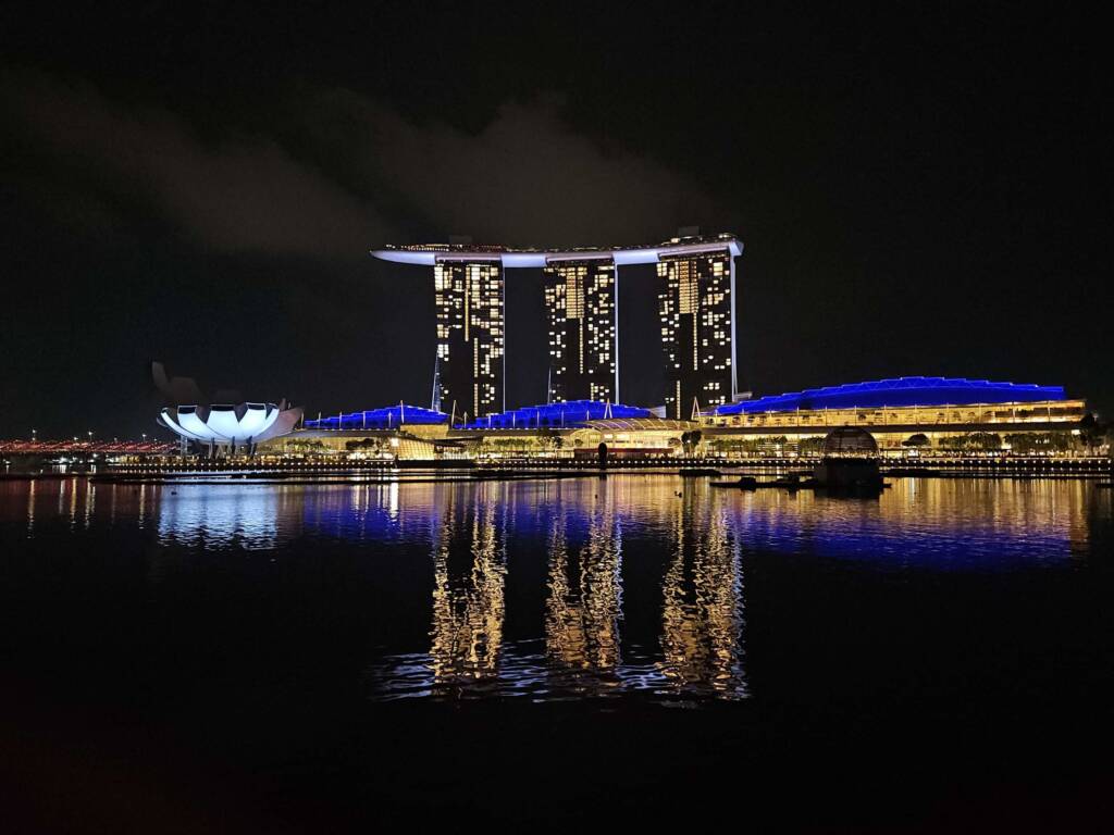 The iconic Marina Bay Sands hotel and skyline lit up at night, representing Singapore on the backpacking itinerary.