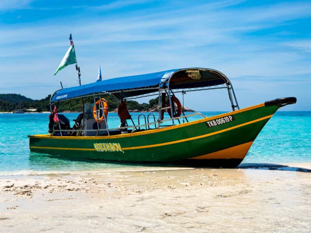 Traditional longtail boat on Redang island taking backpackers snorkelling to spot sea turtles